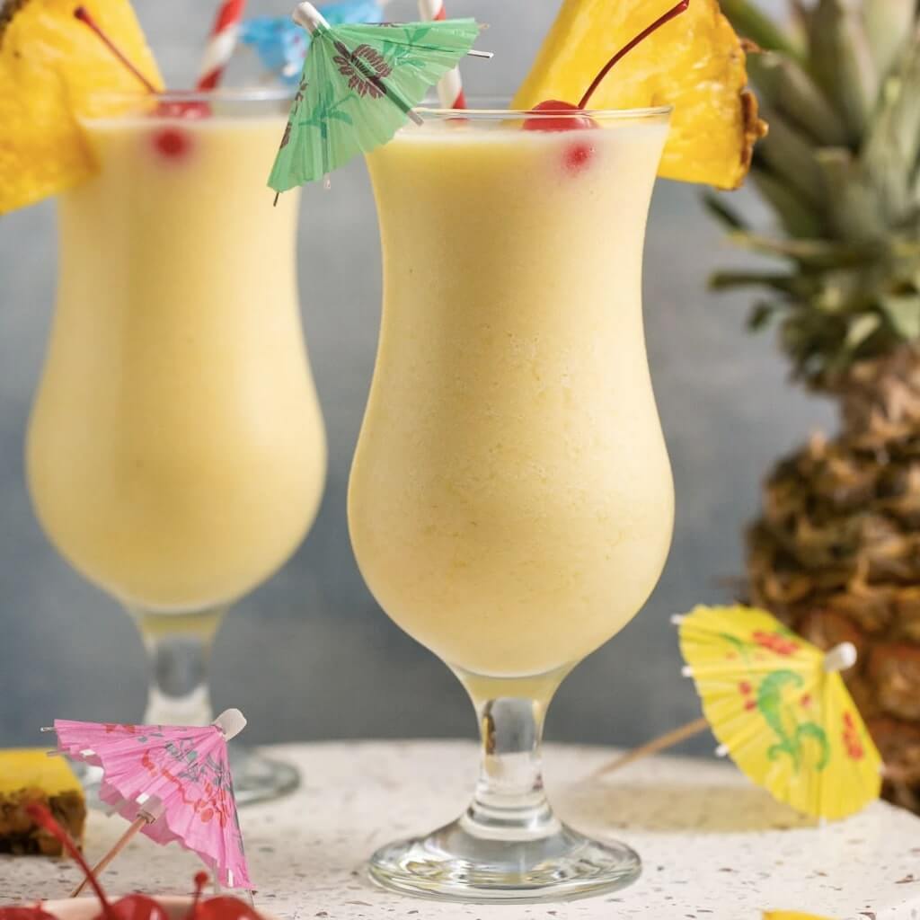 2 Pina Colada cocktails with cocktail umbrellas and cocktails 