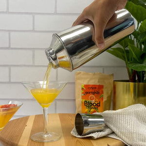 The 750ml stainless steel cocktail shaker being used to pour cocktail