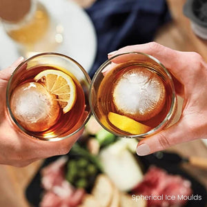 Ladies Cheers with cocktail containing spherical ice cubes