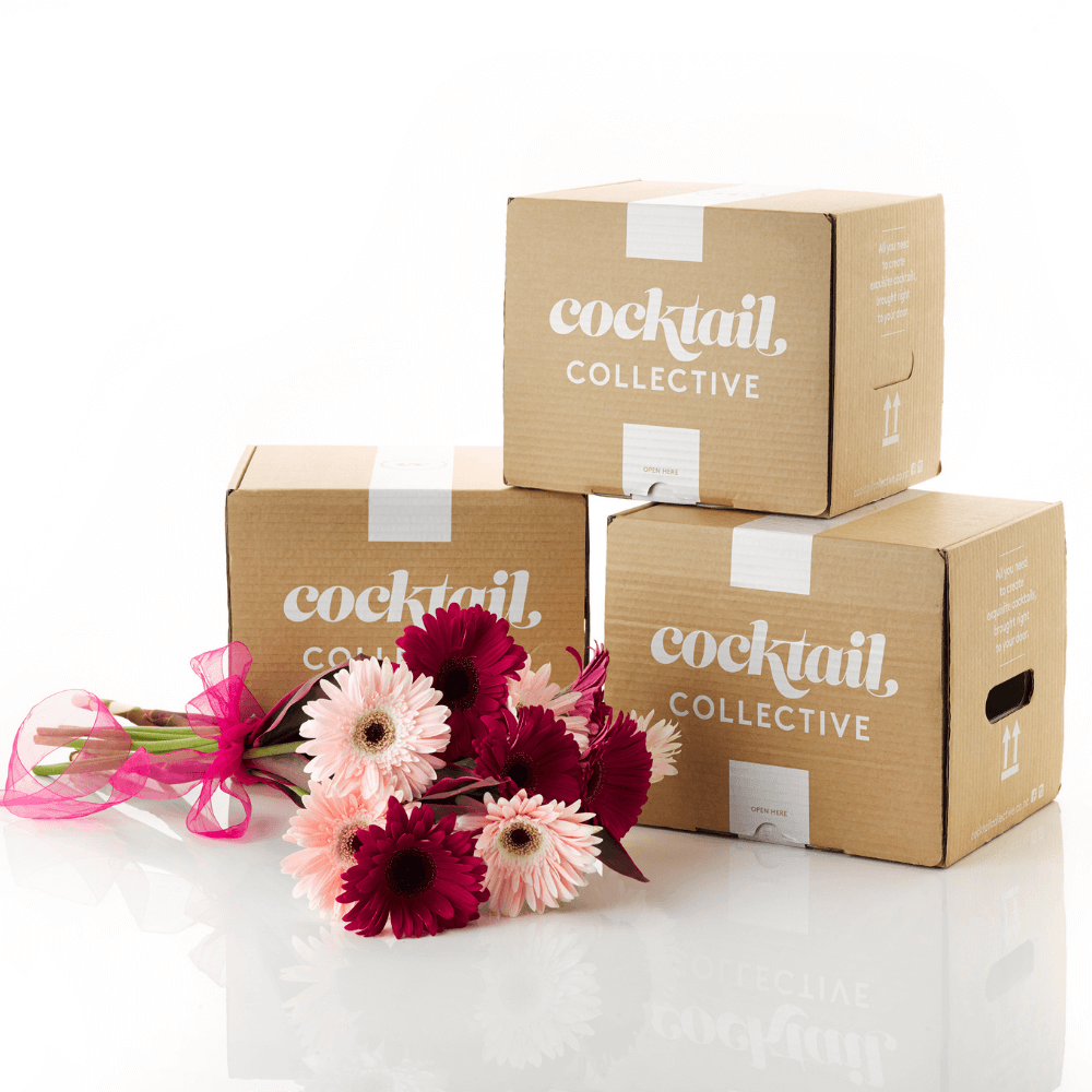 Three Cocktail Collective gift boxes stacked with flowers