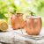 Two Moscow Mules with lemon and mint garnish served in copper mugs