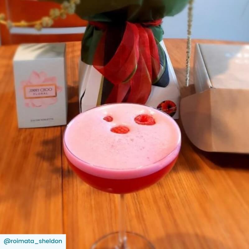 Clover Club cocktail in a couple glass with raspberry garnish