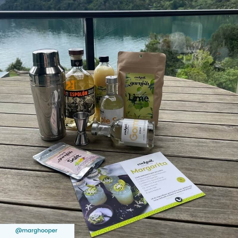 Margarita cocktail ingredients on table by lake