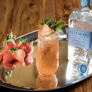 A cherry Fizz Cocktail next to a bottle of Hayman's London Dry Gin 