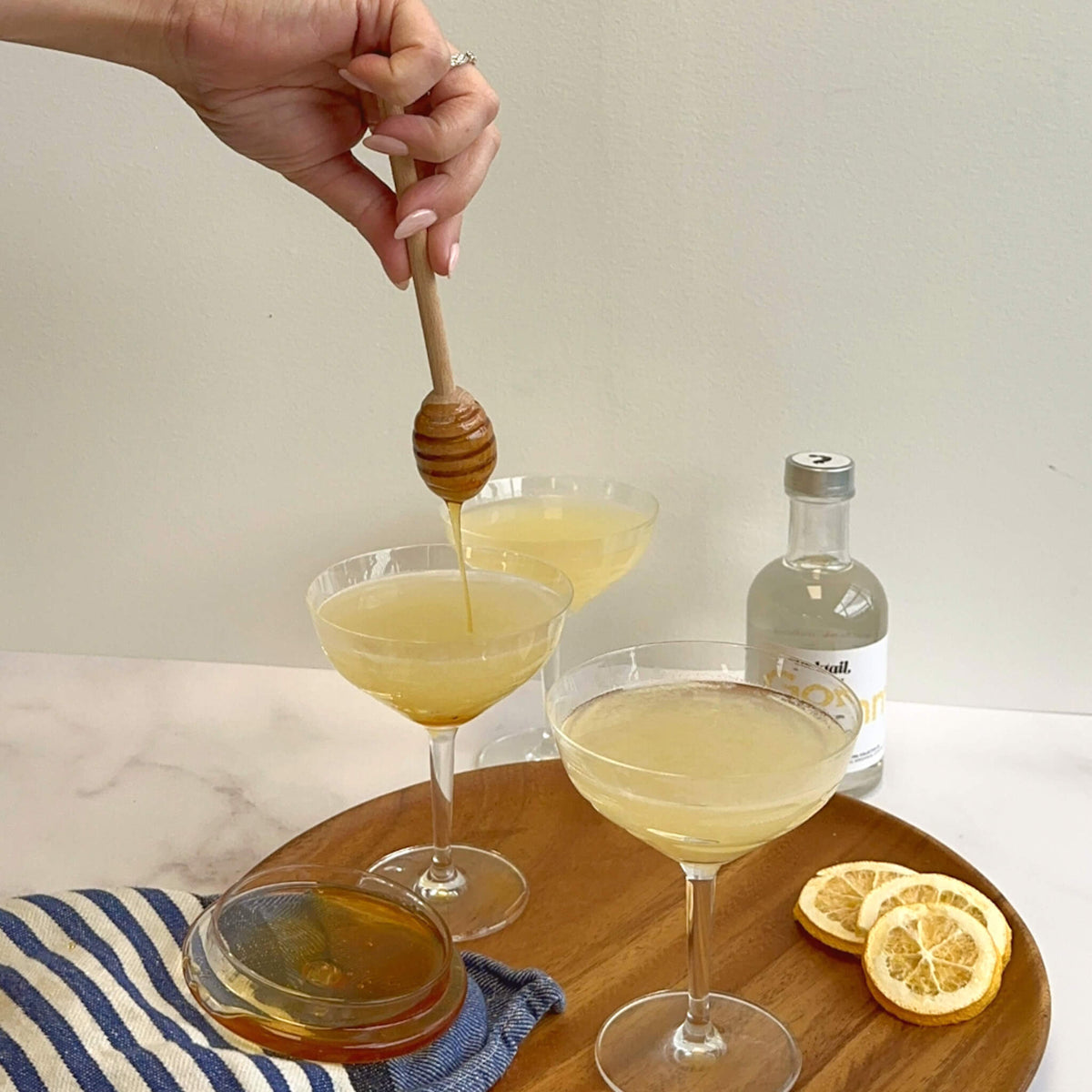 Drizzling honey into The Bee's Knees cocktails