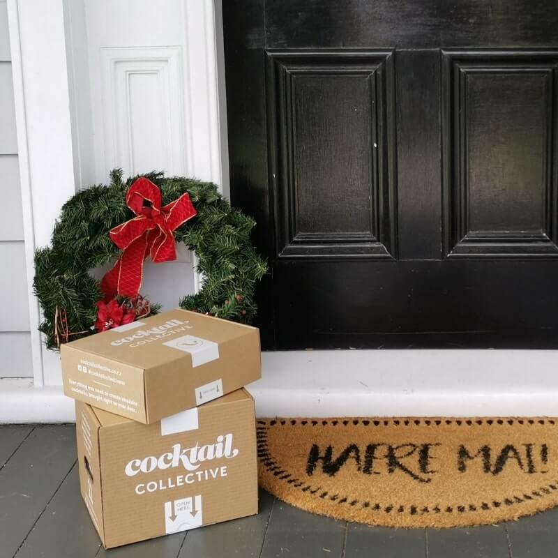Cocktail boxes by door with Christmas wreath