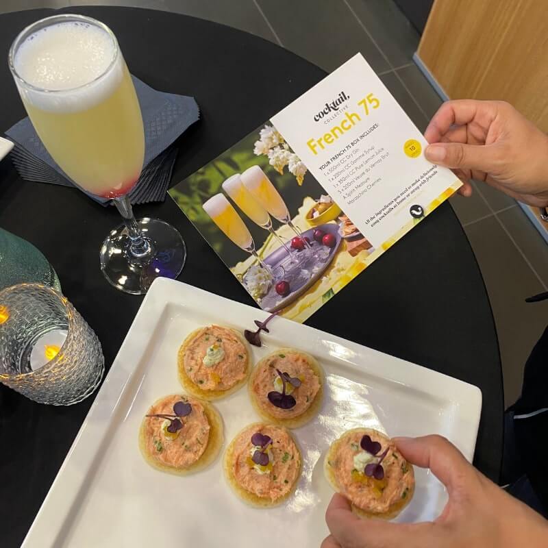 French 75 cocktail and lady holding canapes 