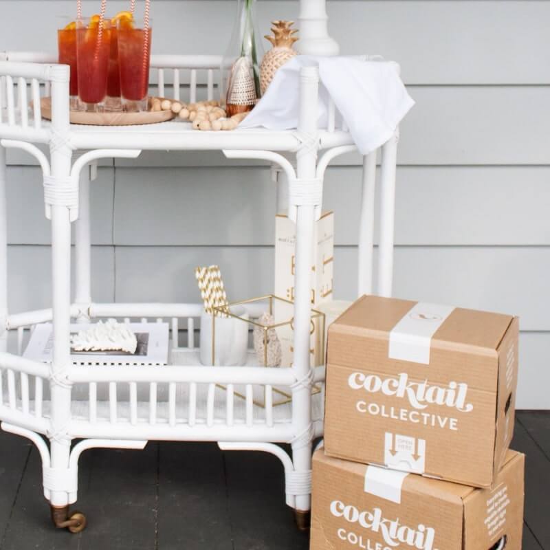 Beachcomber cocktails on a white barcart with Cocktail Collective boxes