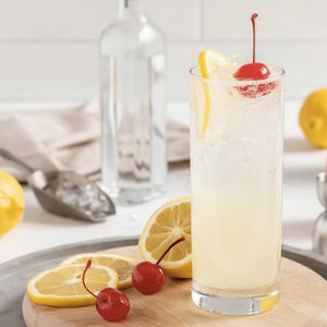 The Honey Collins Cocktail garnished with a lemon wheel and maraschino cherry