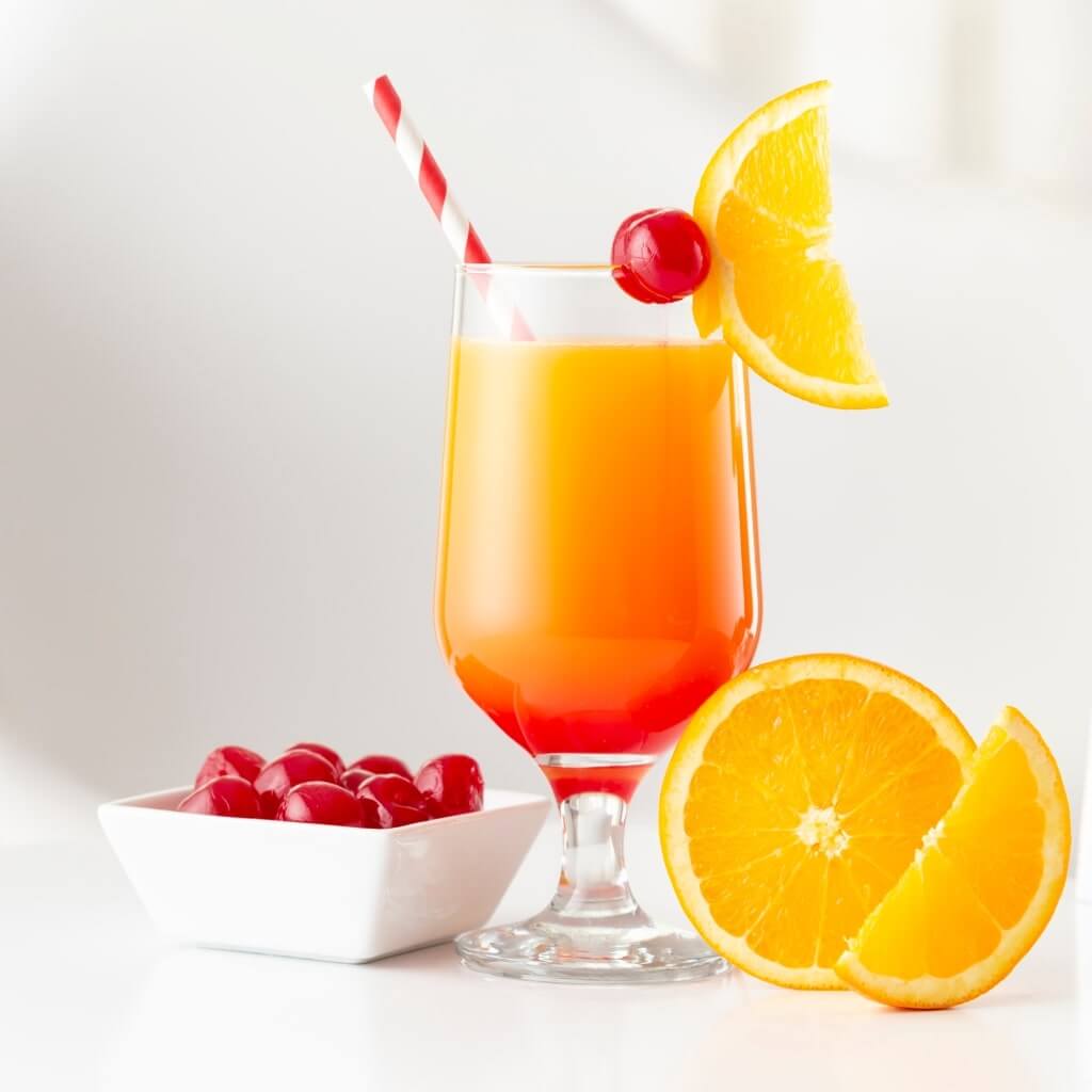 Tequila Sunrise cocktail served with orange and cherry garnish