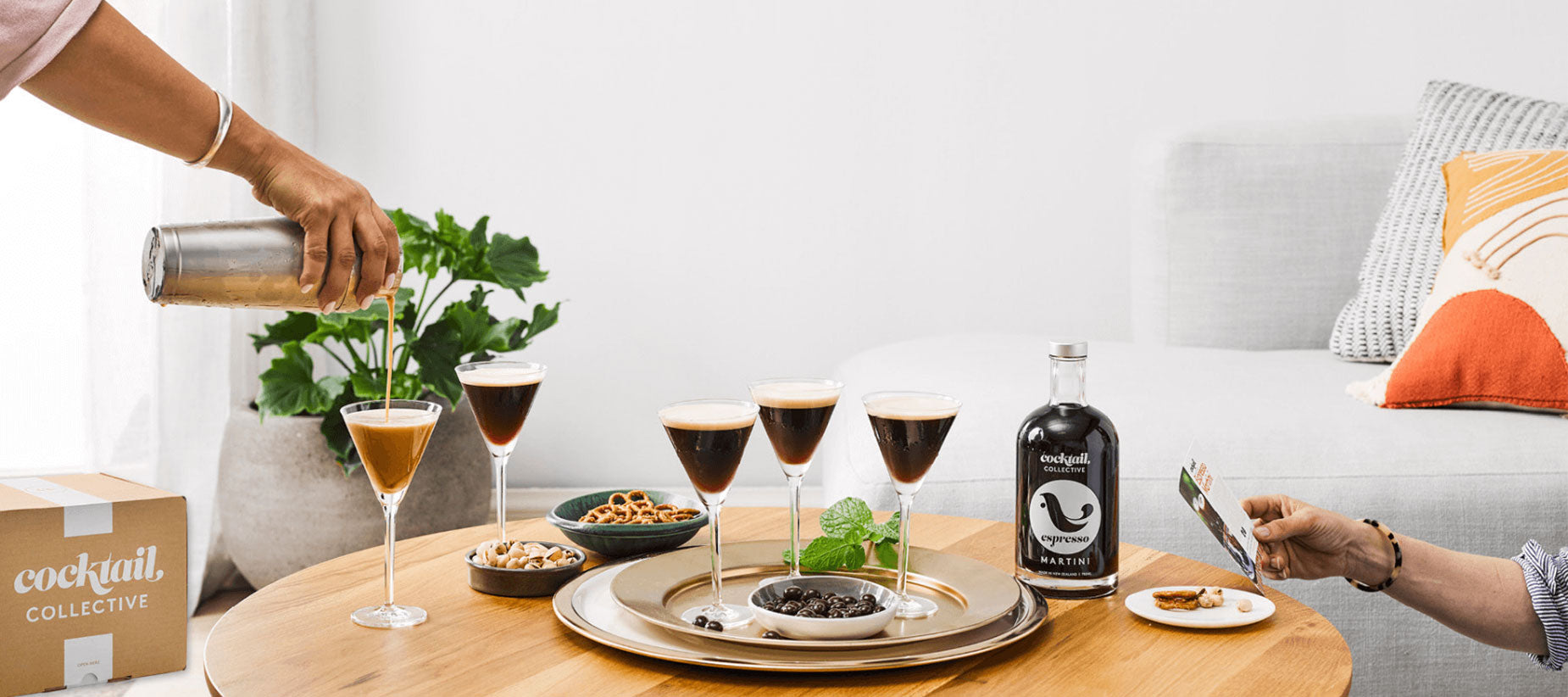 Espresso Martini cocktails being poured on table with nibbles