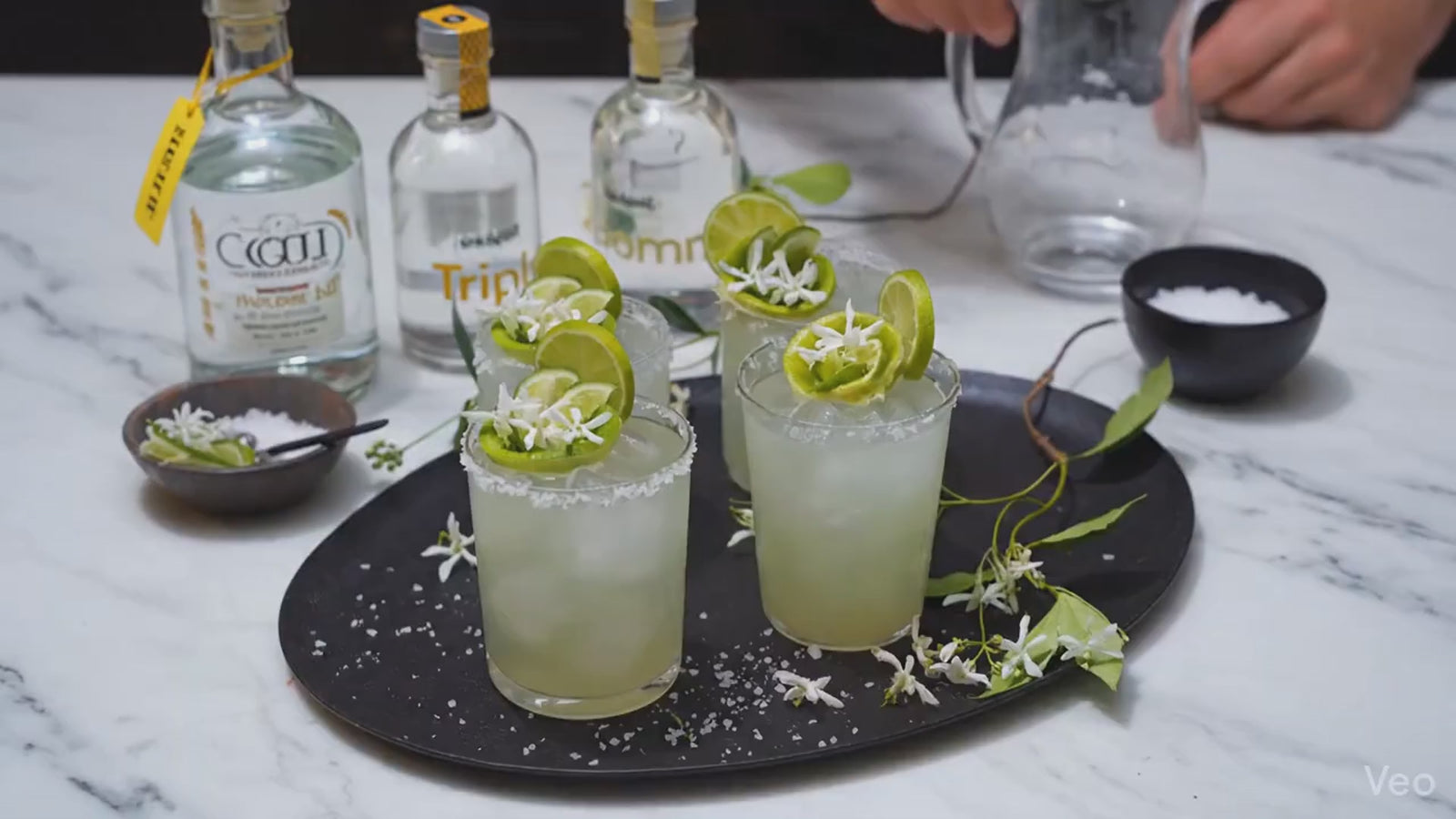 Tray of 3 Margarita cocktails in tumbler glasses with lime rose garnishes
