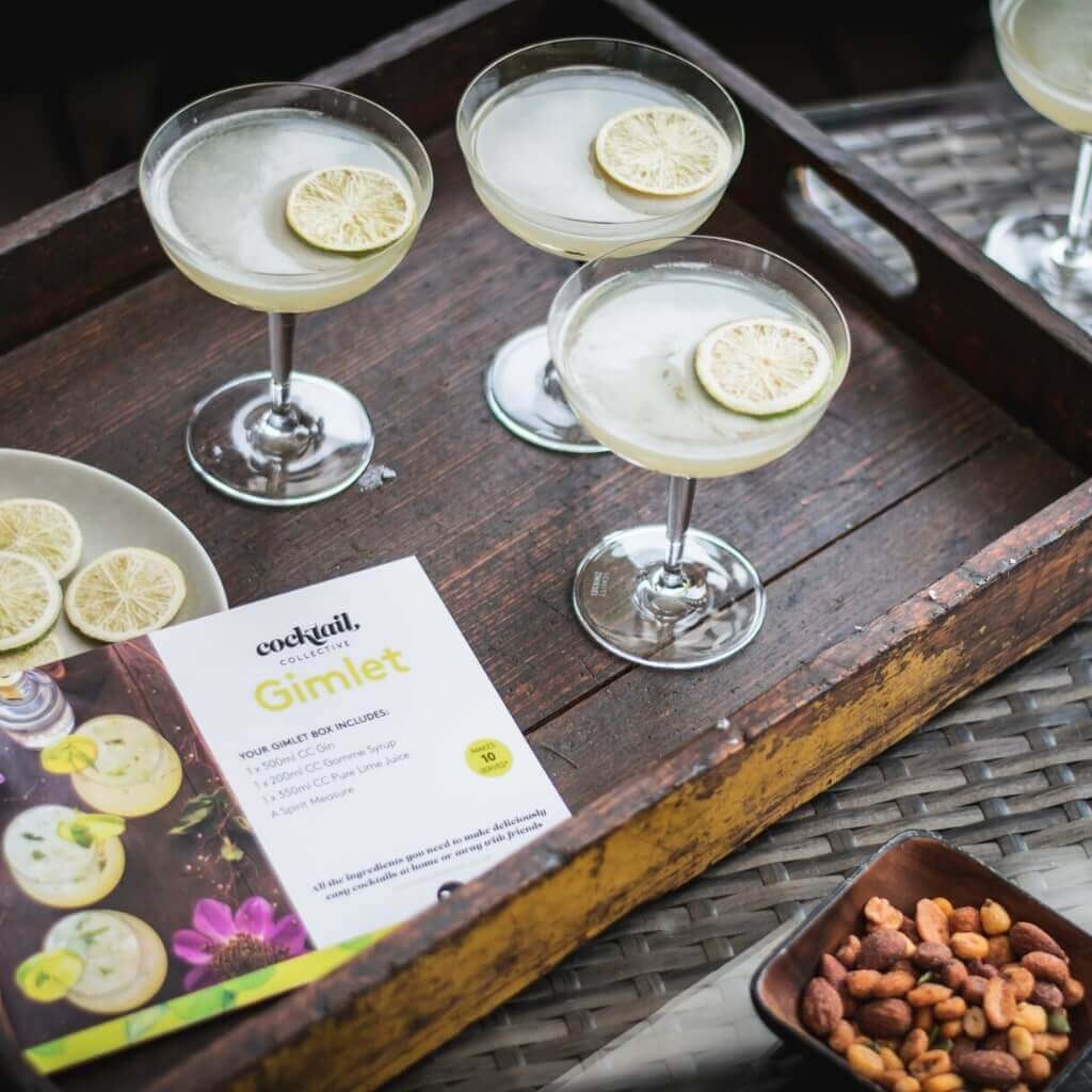 Gimlet cocktails on tray with bowl of nibbles