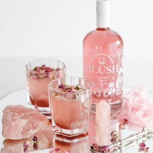 Two Mid- Winter Blush Cocktails surrounded by pink crystal and mini roses 