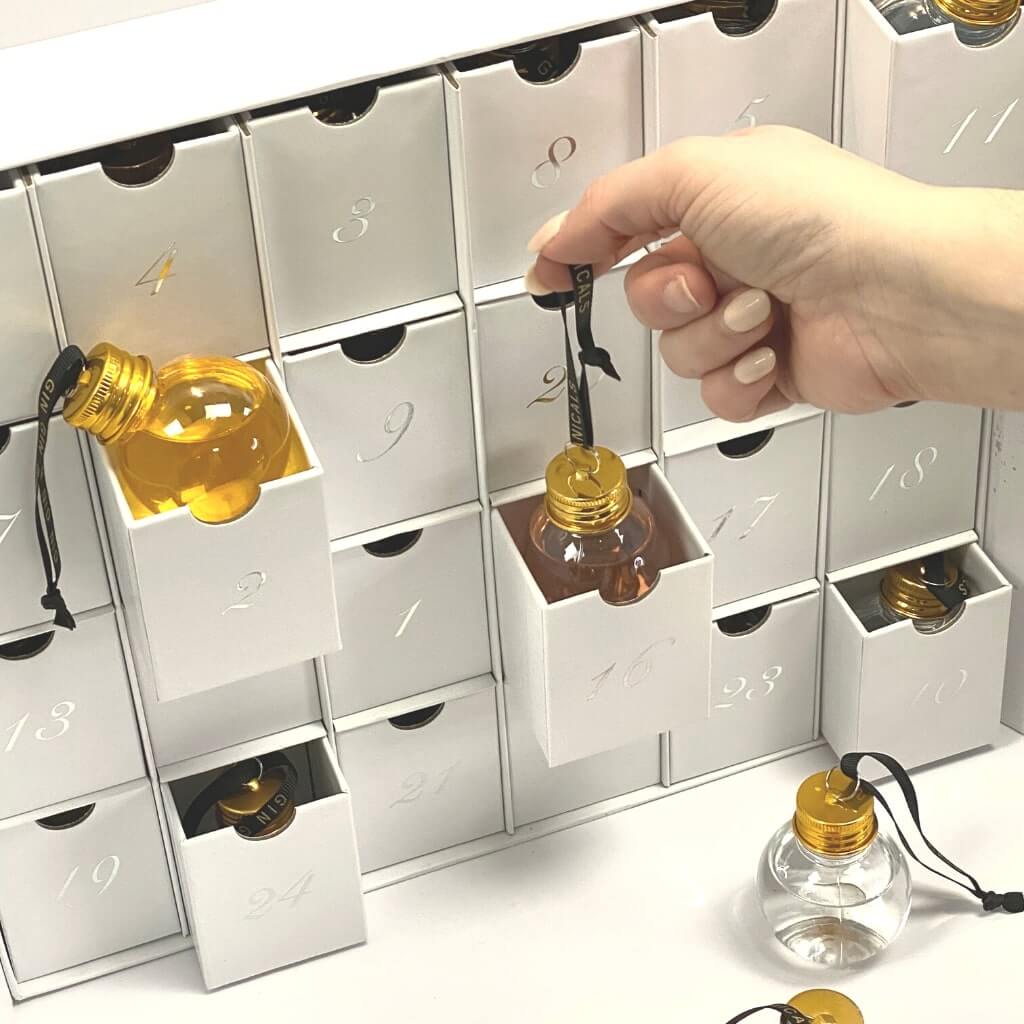 Gin bauble advent calendar with womans hand