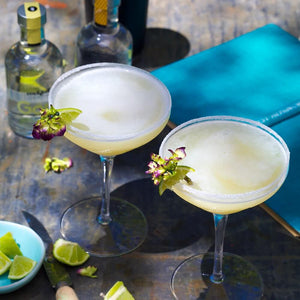 Daiquiri cocktalis in Cocktail Coupes styled on an outdoor table and garnished with flowers