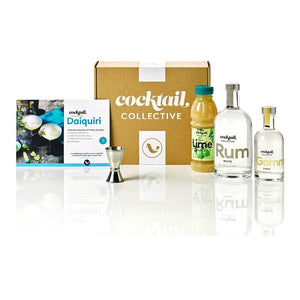 The Daiquiri cocktail kit with a bottle of White Rum, Lime Juice, Gomme Syrup, Recipe card & spirit measure displayed in front of a Cocktail Collective box