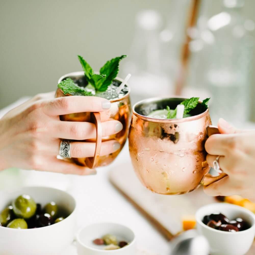 A set of 2 shiny 350ml Copper Moscow Mule Mugs with contoured gold handles from Cocktail Collective 