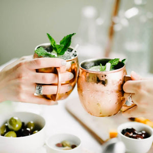 Ladies cheers with 2 Copper Mule Mugs  at dinner table