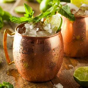 Copper Mule Mugs with Moscow Mule cocktails and mint leaf garnish