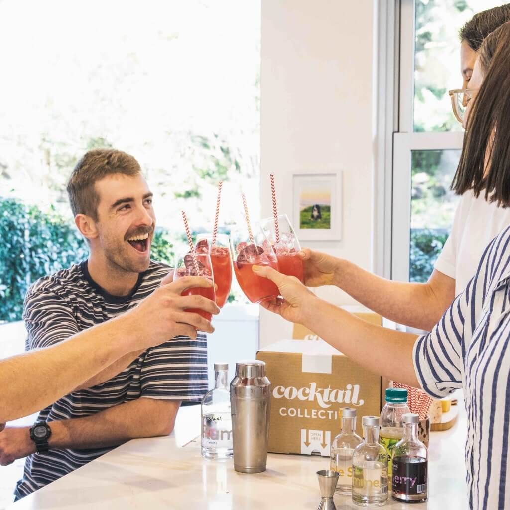 Group saying cheers with Beachcomber cocktails in a kitchen