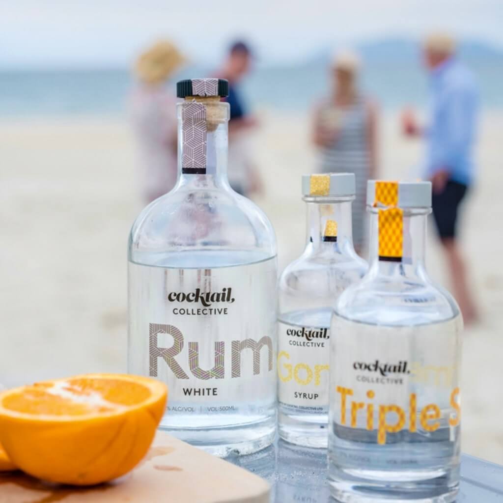 Cocktail Collective Rum, Gomme Syrup and Triple Sec on a table at the beach