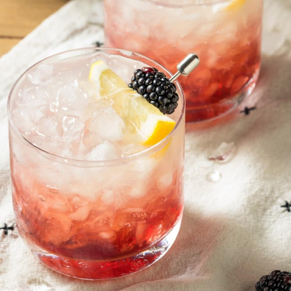 The Bramble cocktail in a tumbler with crushed ice and a fresh fruit garnish