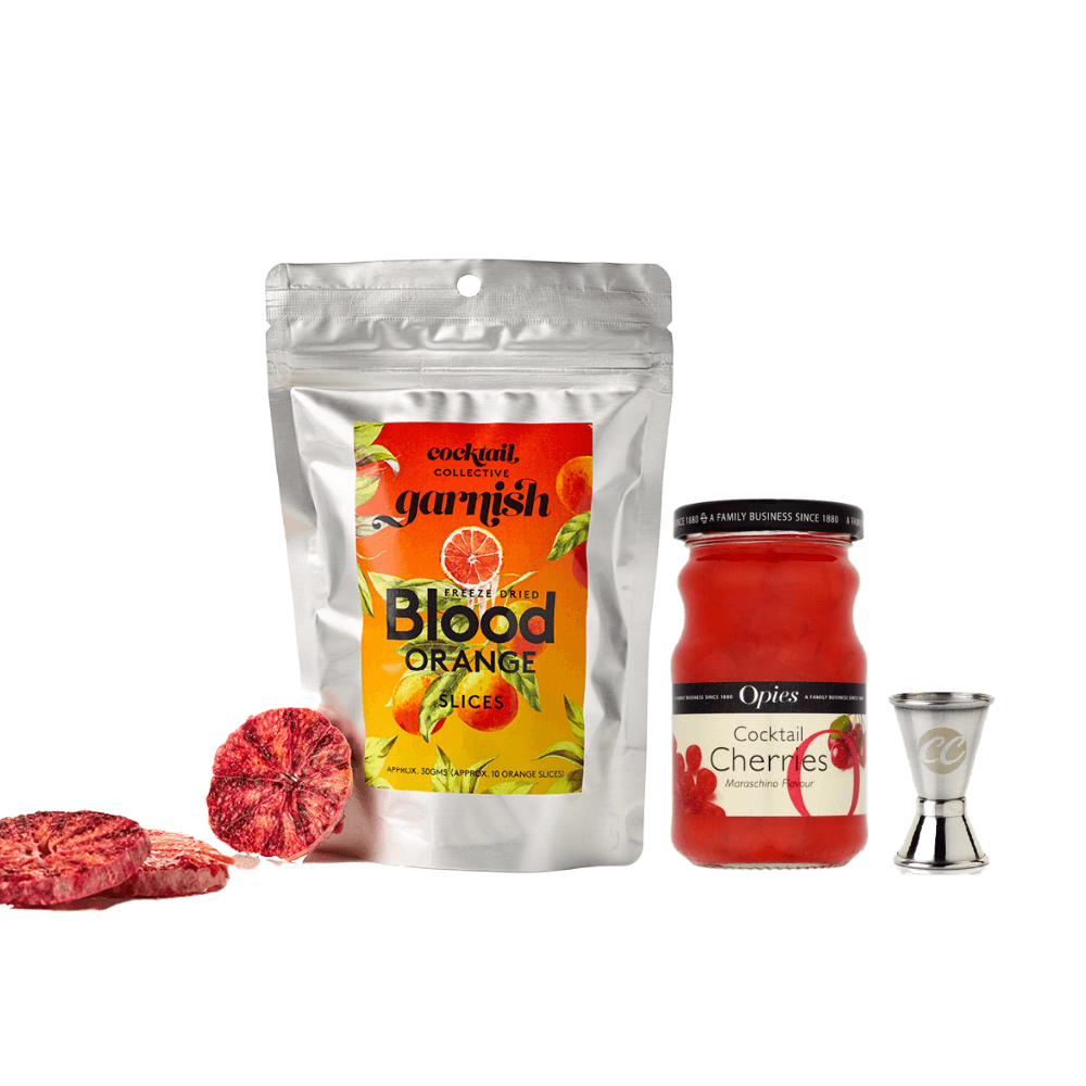 Freeze-dried Blood Oranges slices resting against a packet cocktail garnish, with a jar of Opies Cocktail Cherries & spirit measure
