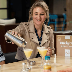 Girl pouring Lemon Drop Martini cocktails into vodka glasses using a 3-piece shaker
